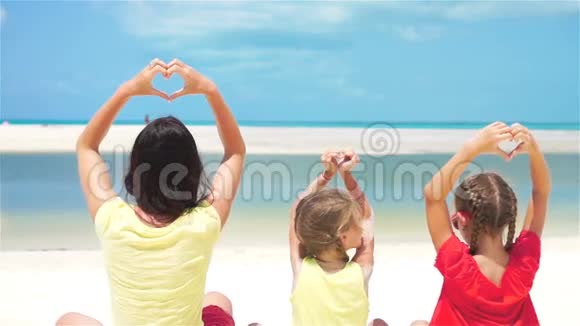 可爱的小女孩和白色海滩上的年轻母亲慢动作视频的预览图