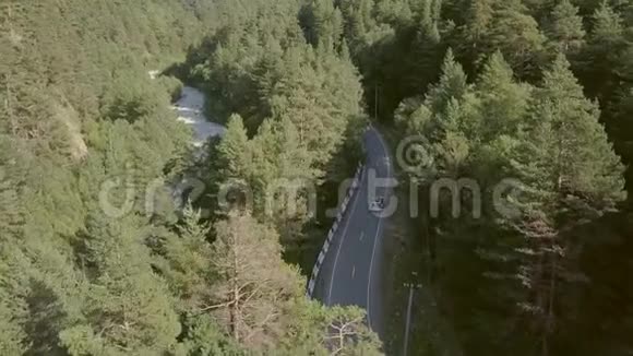 从上面的车上可以看到美丽的景色沿着道路在绿色的森林和山脉之间移动视频的预览图