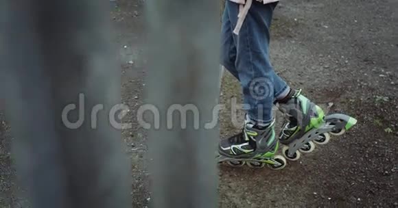 在锈迹斑斑的栅栏附近溜冰鞋上的一个细节红色史诗4k慢动作视频的预览图