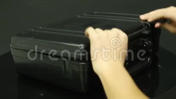 一个男人打开一个带钱的黑色金属手提箱视频的预览图