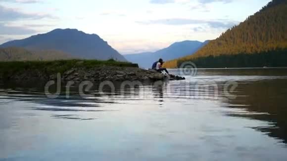日落时分坐在河边的情侣视频的预览图
