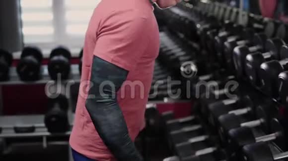 英俊的运动员在健身房训练哑铃二头肌视频的预览图