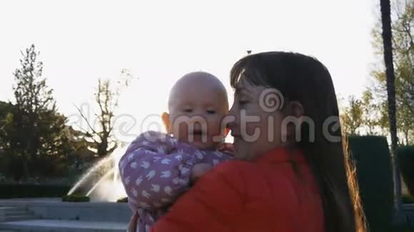 妈妈抱着婴儿用嘴抓鼻子视频的预览图
