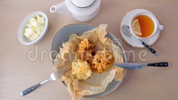 朱莉安用面团在面包纸上的盘子里烤上面有茶和黄油上景视频的预览图