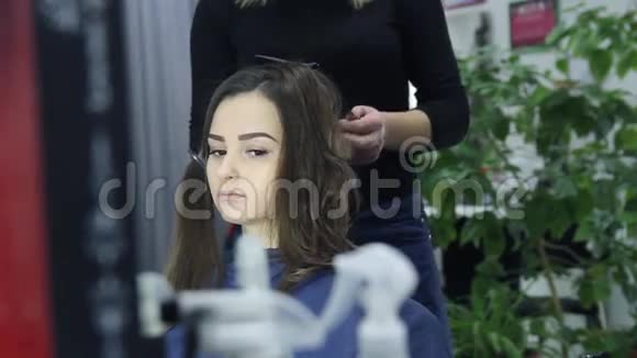 女理发师站在美容院给可爱的年轻女子做发型视频的预览图