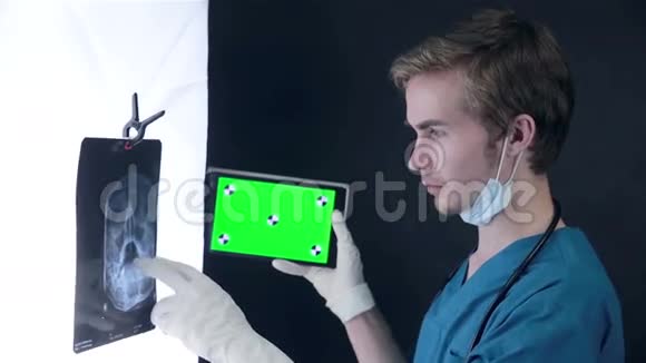 男性医生检查x光图像使用绿色屏幕片视频的预览图