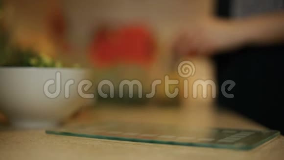 女青年在厨房的玻璃板上切番茄视频的预览图