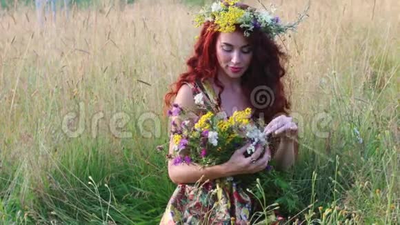 戴着花环的漂亮女人坐在干草里夏天捧着野花视频的预览图
