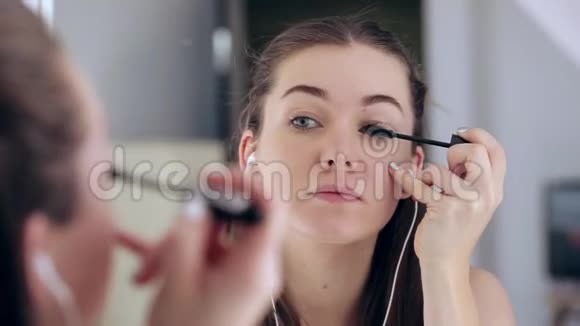 美丽的少女化妆在镜子里欣赏自己有魅力的女人在家照镜子视频的预览图