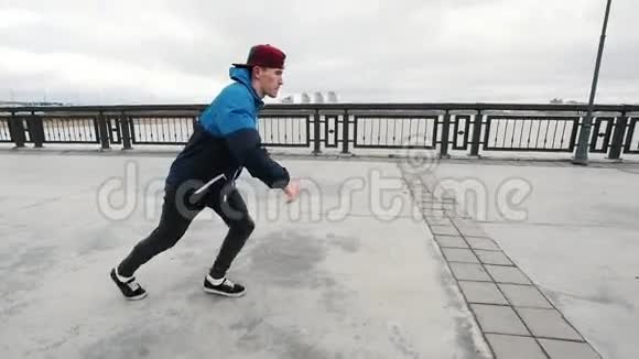 健身青少年表演杂技翻筋斗在长廊帽从他的头慢慢飞起视频的预览图