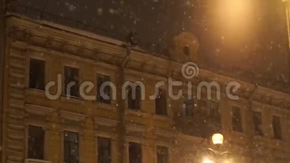 人从楼顶降雪城市夜间大雪纷飞视频的预览图