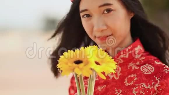 美丽的越南女孩穿着红色的传统服装戴着黄色的花特写镜头视频的预览图