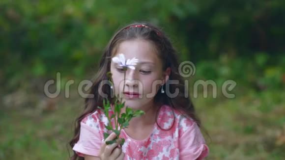快乐的小女孩在花园里玩一朵花花儿破了视频的预览图