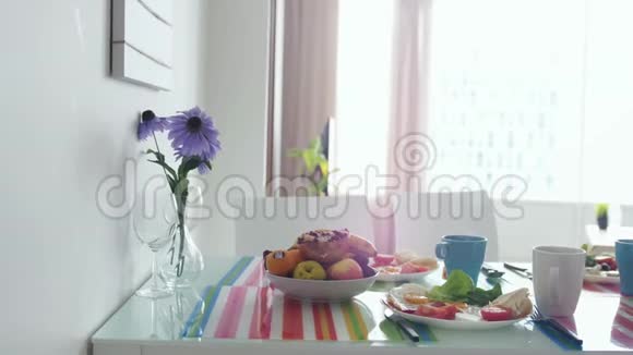 早上的早餐桌上有花束在公寓厨房里有水果盘慢动作3840x2160视频的预览图