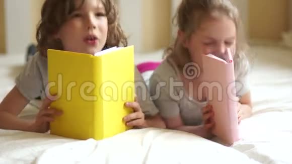 两个孩子男孩和女孩哥哥和姐姐在床上看书白天视频的预览图