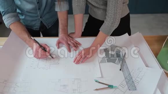 在办公室里两个工人正在讨论建筑图纸近距离拍摄手臂移动图片观看视频的预览图