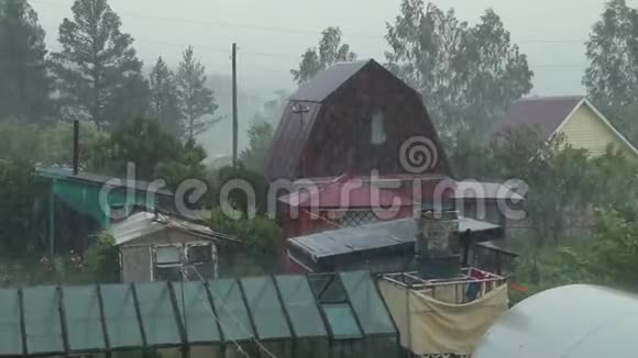 村里夏雨多云天气雨滴落在房子上视频的预览图