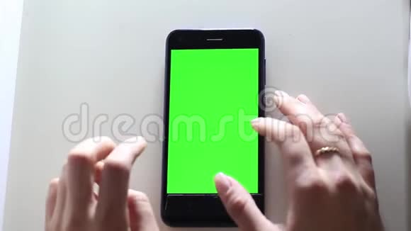 女性手拿着一个带有绿色屏幕的移动设备铬键视频的预览图