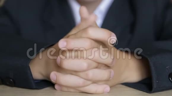 3男孩坐在桌子旁摸着他的手指视频的预览图