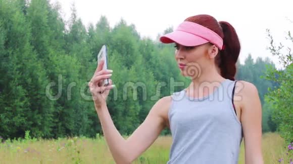 戴帽子的年轻女子夏天在森林里自拍视频的预览图