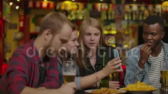 一群年轻的朋友在酒吧里喝酒笑视频的预览图