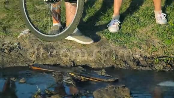 人们用自行车横过小溪的腿视频的预览图