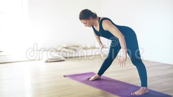 一位美丽的白人女子在室内做瑜伽的肖像侧视视频的预览图