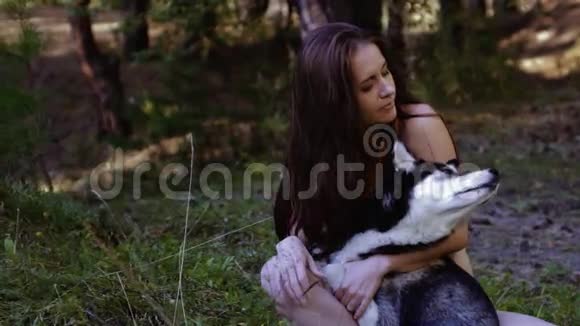 神秘的女人和她的狗坐在大自然中专注地看着某件事的画像视频的预览图