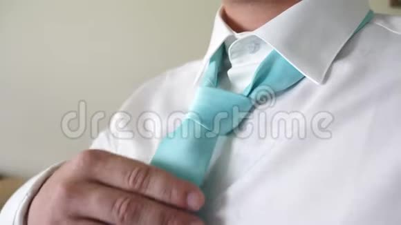 一个商人早上去上班时用双手系着蓝色的领带系着白色衬衫企业雇员的概念视频的预览图