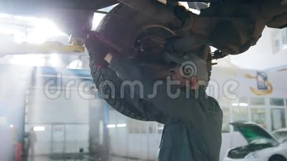 车库汽车服务汽车底部的机械师检查车轮关闭视频的预览图