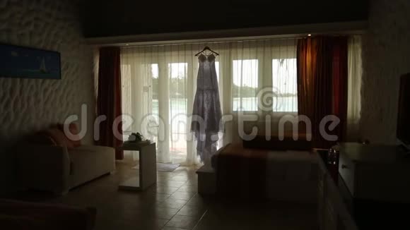 孤立的新娘婚纱在平房的房间背景上有蓝色泻湖相机在滑块上后面的海洋风景视频的预览图