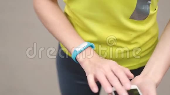 女性手上有运动手环和智能手机视频的预览图