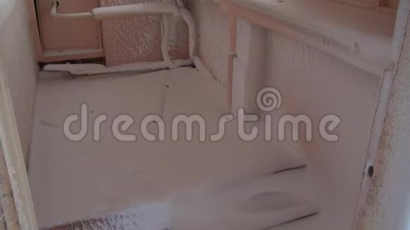 在荒芜的城市里被毁的房子里冰冷的窗户和白雪覆盖的房间视频的预览图