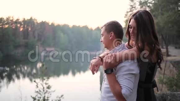一对夫妇在森林里的河边拥抱视频的预览图