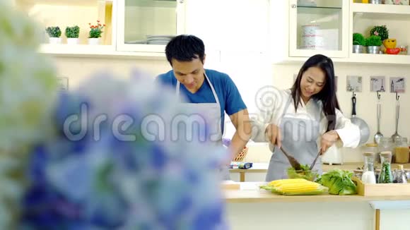 年轻的亚洲夫妇喜欢在厨房准备食物视频的预览图