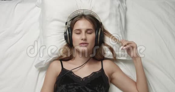 性感女人在床上戴着大耳机视频的预览图