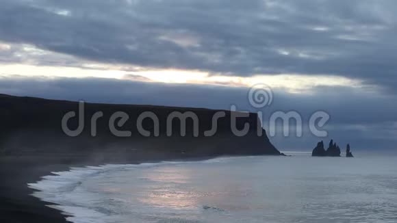 大海上的日出波浪在黑色的沙滩上奔跑岩石和太阳冰岛视频的预览图