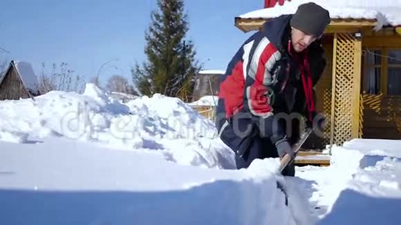 往堆上扔雪一个手里拿着铲子的人在他的房子往堆里扔雪里面有录像视频的预览图