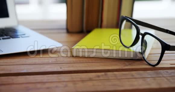 4k木桌上的笔记本电脑书籍和眼镜视频的预览图