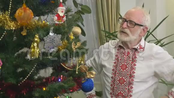 可爱的老人在圣诞树旁笑视频的预览图