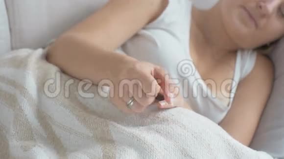 躺在床上搓手的年轻紧张的女人特写镜头视频的预览图