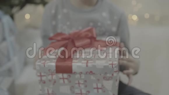 近距离观看快乐兴奋的小男孩打开圣诞礼物盒惊讶地坐在新年树附近视频的预览图