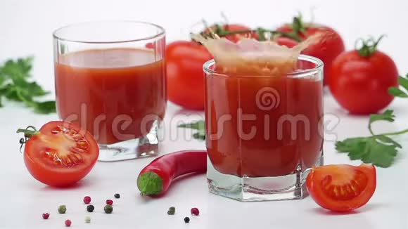 成熟的番茄瀑布成一杯番茄汁视频的预览图