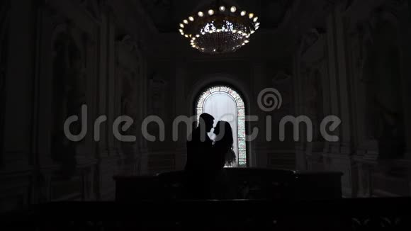 可爱的一对夫妇在婚礼上拥抱宫殿的剪影视频的预览图