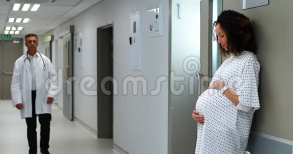 孕妇在医生走走廊时摸着肚子视频的预览图