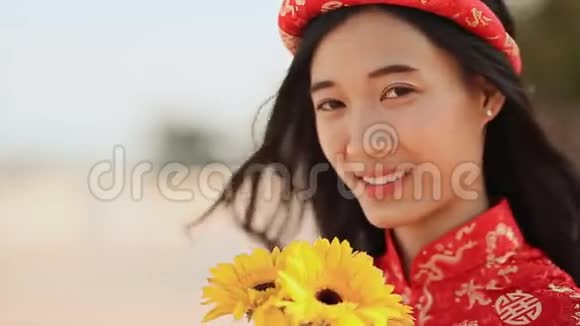 美丽的越南女孩穿着红色的传统服装戴着黄色的花特写镜头视频的预览图