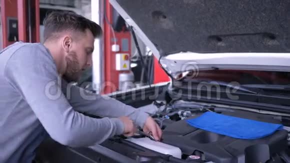 汽车业务机械师修理汽车与开放引擎盖在工作在服务站修理汽车与开放引擎盖在视频的预览图