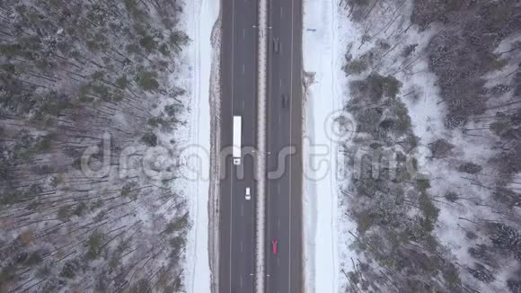 冬季公路上的俯视汽车交通在冬季道路上行驶的汽车和卡车视频的预览图