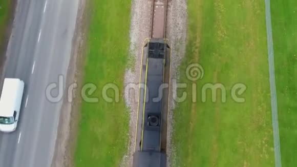 货运列车在日出时穿过风景优美的乡村城市空中镜头视频的预览图