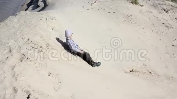 孩子们滑下一座沙地山视频的预览图